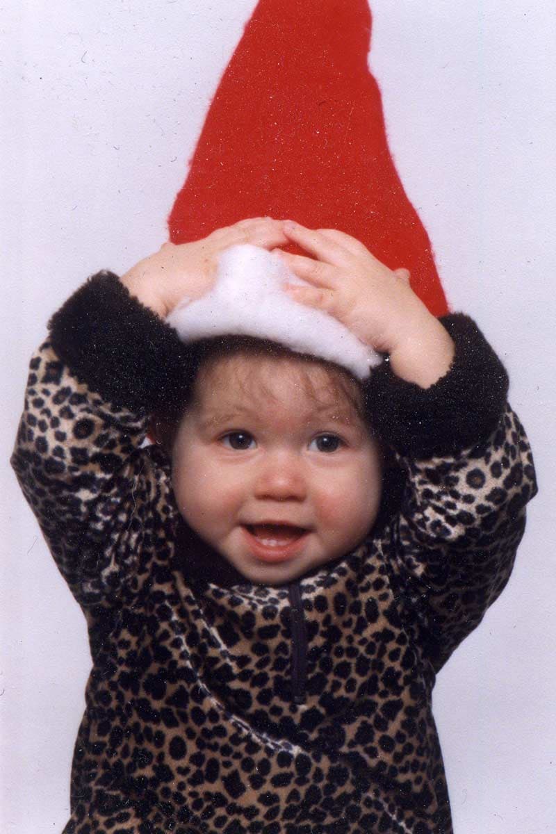 A baby wearing a Santa hat